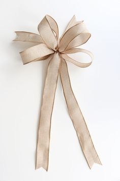 a beige ribbon tied to a white wall