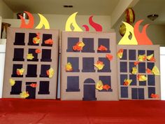 two doors with fire and flames cut out of them sitting on a red carpeted floor