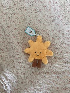 a yellow stuffed animal with a tag on it's ear laying on a bed