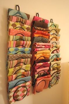 a wall hanging organizer filled with lots of colorful fabric