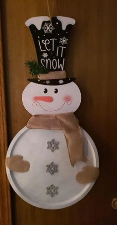 a paper plate snowman hanging on a door