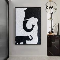 a black and white painting hanging on the wall next to a mirror in a bathroom