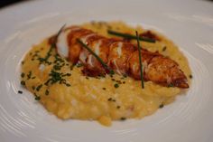 a white plate topped with shrimp and grits