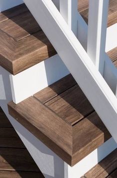 wooden steps with white railings and wood slats on the bottom part of them