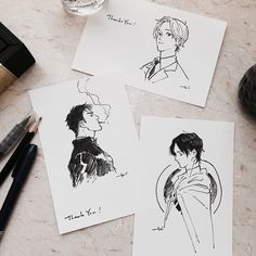 three drawings of two men and one woman on paper next to some pens, ink