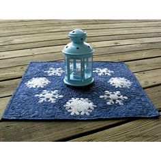 a blue lantern sitting on top of a wooden table next to a blue and white rug