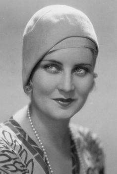 an old black and white photo of a woman wearing a turban with pearls