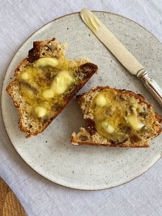 two pieces of bread on a plate with a knife