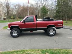 a red pick up truck parked in a parking lot