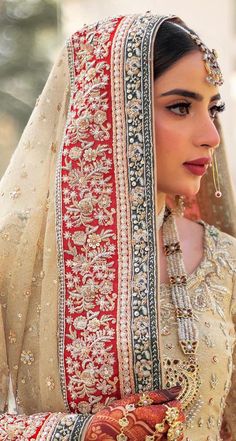 a woman wearing a red and white bridal outfit