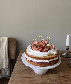 a cake sitting on top of a wooden table next to a white plate with fruit