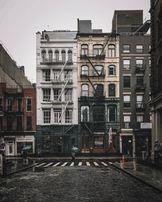 an empty city street with buildings in the background