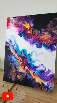 an abstract painting is being displayed on a table