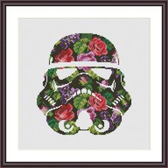 a cross stitch pattern with a star wars trooper helmet on it's face and flowers in