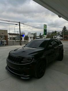 a black jeep is parked in front of a gas station with no one around it