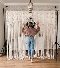 a woman standing in front of a curtain with her hands behind her head and arms outstretched