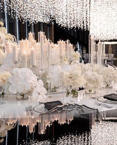 the table is set with white flowers and candles