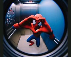 the spider man is looking through a round hole