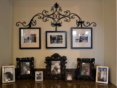 a dining room table with pictures on the wall above it and a lamp next to it