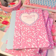 the composition book is pink and has hearts on it