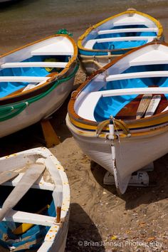 three small boats are sitting on the beach