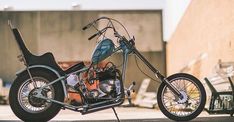 a motorcycle parked on the side of a road next to a bench and building in the background