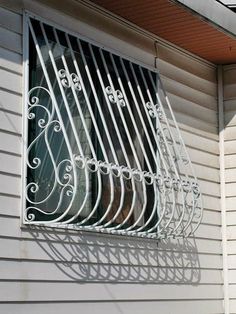 an iron window grill on the side of a house