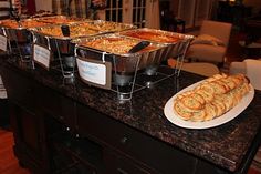 a table filled with lots of food on top of a black counter