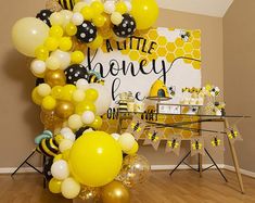 a bunch of balloons that are in front of a sign and some tables with chairs