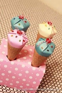 three ice cream cones sitting on top of a pink and white polka dot covered box