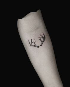 a black and white photo of a deer's antlers tattoo on the arm