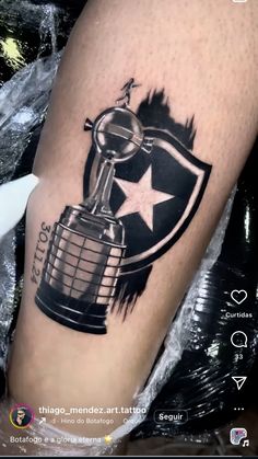 a tattoo on the leg of a person with a trophy in front of it and an american flag