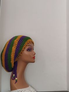 a mannequin head wearing a crocheted hat with purple, yellow and green stripes