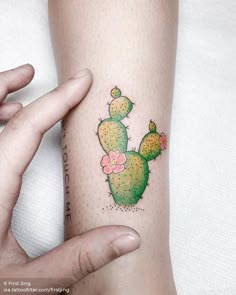 a woman's arm with a small cactus tattoo on it