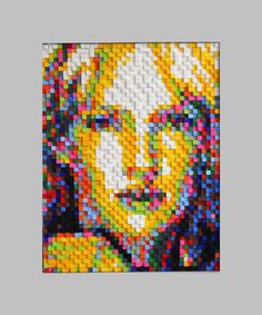 a close up of a painting made out of legos on a gray background with the image of a man's face in multi - colored blocks