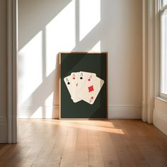 two playing cards are on the floor in front of a framed photograph with sunlight streaming through it