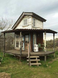 a small wooden house sitting on top of a lush green field