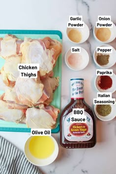 ingredients to make chicken thighs laid out on a cutting board, including seasonings and sauces