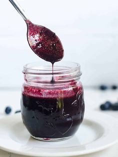 a spoon full of blueberry jam on a white plate