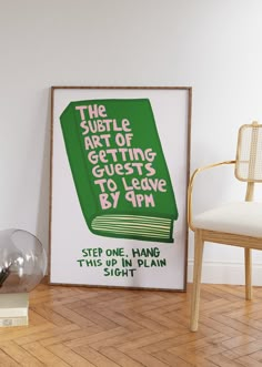 a green book poster sitting on top of a hard wood floor next to a chair