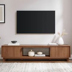 a living room scene with focus on the entertainment center and large screen tv mounted above it