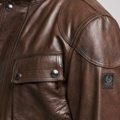 Introducing the Trialmaster, Belstaff's pinnacle design crafted from oiled, hand-waxed leather. Artisanal finish and check-lined cotton twill interior exude sophistication. The jacket boasts a mandarin collar, buckle-adjusted belt, reinforced shoulders, and 4 pockets, including a convenient slanted pocket on the left side. Experience unmatched style and functionality. Belstaff Trialmaster, Leather Jacket Mens, Paul Shark, Wax Jackets, Loafer Slippers, Cardigan Shirt, Luxury Watches For Men, Leather Jacket Men, Jogger Jeans