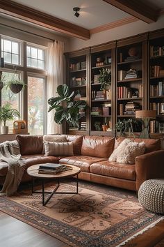 a living room filled with lots of furniture and bookshelves next to a window