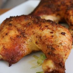 two pieces of chicken sitting on top of a white plate