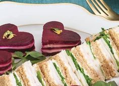 a plate topped with cut in half sandwiches and radishes