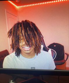 a young man with dreadlocks on his face