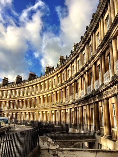 an old building with many windows and balconies on the outside, against a cloudy blue sky