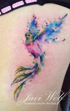 the back of a woman's thigh with watercolor tattoos on it