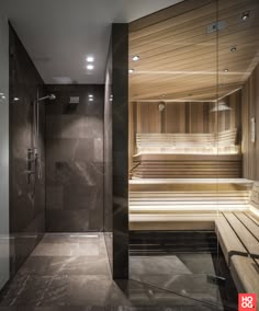 a sauna room with two benches and a glass shower stall in the corner,