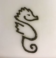 a metal sea horse on a white surface